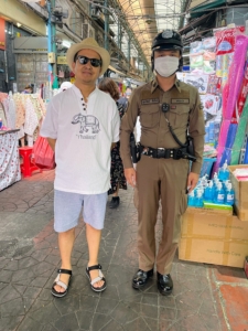 방콕 시내를 걷는 동안 치어링은 멈춰서 경찰관과 함께 포즈를 취했습니다.