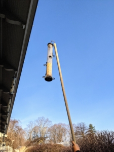 When filling the feeders, we use a pole with a hook on one end. Each feeder is carefully removed from its hanging location and refilled on the ground.