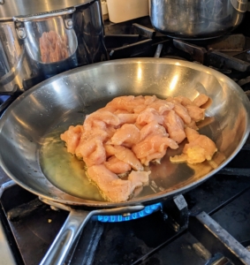Elvira heats a tablespoon of oil in a large skillet over high and drops in the chicken to cook through.