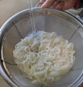 Once the noodles are done, they are drained and rinsed under cold water and tossed with two teaspoons oil to prevent sticking.