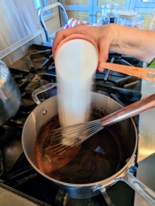 Here she adds two cups of sugar and continues to stir.