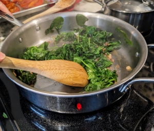 Once the spinach is wilted, she adds the vinegar and removes from the heat.