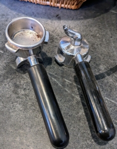 These are the portafilters. On the right, one can see the fixed spout on the bottom. These portafilters hold the ground espresso coffee from grinder to machine. These should also be cleaned after every use. Whenever cleaning any kind of espresso or coffee maker equipment and parts, avoid using dishwashing detergent, which could affect the taste of the beverages. One can use a white vinegar and water solution instead.