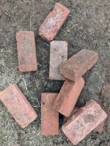 I have thousands of these red clay bricks. “Pressed red” is the general term given to solid red bricks traditionally manufactured from clay, pressed into individual molds by hand, and then heated at very high temperatures. Each of these antique bricks measures about eight and-a-half inches by four inches.