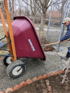 Fernando uses our trusted Scenic Road wheelbarrow to transport the gravel from the truck to the path. We have more than a dozen of these wheelbarrows - they're great for so many jobs around the farm.
