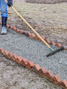 The gravel is spread evenly with a hard rake.