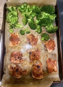 The chicken thighs and broccoli florets are fresh from the oven and looking so delicious. The chicken is brushed with any remaining barbecue sauce and then served.