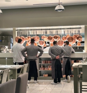 Here, the wait staff gathers at the large counter waiting to bring out various dishes. Above are the hanging copper pans in a variety of sizes from my MARTHA by Martha Stewart collection.