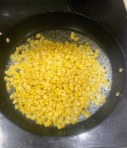 Brian then makes the creamed corn. He melts four tablespoons butter into a large saucepan over medium heat and adds all the corn.