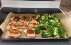 Brian spreads the broccoli onto the same baking sheet and returns it to the broiler. It is cooked for another seven minutes depending on the oven - until the chicken is cooked through, the glaze is browned in spots, and the broccoli is lightly charred.