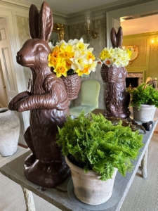 On this table in my foyer, guests are welcomed by these two larger than life-sized faux chocolate bunny figurines holding pretty daffodils from the garden. Wait until you see my long daffodil border this year – the flowers are coming up so wonderfully.
