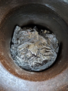 To protect the urn, we lined the bottom with aluminum foil. Because these will be dry arrangements, there wasn't a huge concern about water leakage, but the foil provides a safeguard against moisture and potential scratches.