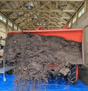 Back in the Equipment Barn, Phurba drops loads of composted manure and top soil onto a tarp for potting. Composting manure above 131-degrees Fahrenheit for at least a couple weeks kill harmful pathogens, dilute ammonia, stabilize nitrogen, kill weed seeds and reduce any objectionable odors. I am so proud of the nutrient-rich soil we make here at the farm.