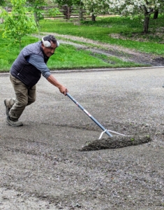 Around the stable, Pete uses a long landscape rake to push gravel that has washed to the sides back where it belongs. Over time, rain and traffic cause the gravel to shift or run-off a specific area.