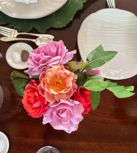 Small faux bois vases were lined up along the center of the table and filled with colorful rose blooms.