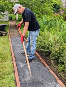 Once all the bricks are in place, Fernando levels a layer of stone dust in the path. Stone dust is a non-porous material, which is good to use under gravel. It will stop heavy rain water from seeping below and reduces the risk of shifting or damaging the bordering bricks.