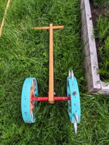 This is called a rolling dibbler available at Johnny's Selected Seeds. It comes in single form like this one or with multiple wheels. It allows one to create evenly spaced impressions in the soil for accurate transplanting.