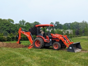 And then the digging begins. Chhiring maneuvers our Kubota M62 tractor loader and backhoe to dig a trench for the trees.