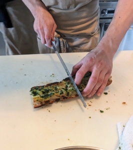 Chef Pierre and his sous chef, Aaron, made delicious herbed butter bread to start. Here, Aaron cuts the baguettes still warm from the oven...