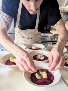 Meanwhile, here is Aaron helping to plate the first course - our beet borscht with carrots and onion.