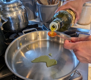 Next, Elvira heats two teaspoons of extra virgin olive oil in a large skillet over medium-high heat.