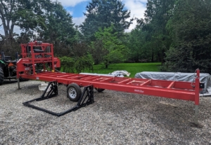 This piece of equipment comes with a 23-horsepower engine, an adjustable power feed, a power throttle, power height adjustment, a hydraulic log loader, hydraulic log turner, and a heavy-duty 24-foot trailer.