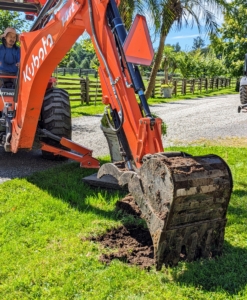 Meanwhile, my outdoor grounds crew foreman, Chhiring Sherpa, begins digging the holes with the backhoe of our trusted Kubota M62 tractor.