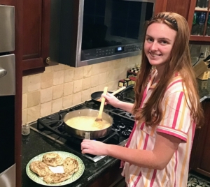 Here's Claire cooking the orzo in the same skillet as the chicken. The orzo is cooked, and then chicken broth is added before the chicken is placed on top of the orzo and baked in the oven.