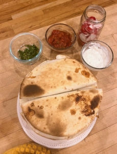 Here are the quesadillas perfectly browned and still warm before Brian adds the delicious toppings of sour cream, pickled radishes, and the remaining cilantro, with salsa on the side for dipping.