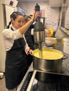 Here, a giant commercial immersion blender is used to mix a batter.