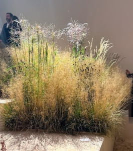 Both sides of the runway at the Garde Républicaine were decorated with a "meadow" of wildflowers, reeds, and tall grasses. There was also straw dust on the floor of the venue.