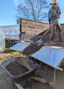 It is easier to walk around the interior space when the gravel is small, so Jimmy transports smaller pea gravel to place on top of the larger gravel bed inside.