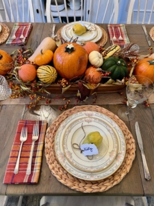 Joey says, "I decided to forgo a tablecloth as the wood table adds to the rustic look and mixing the china with the more casual elements like the woven chargers adds an interesting touch. I finished with special name cards tied around pears with twine."