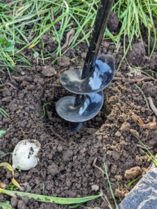 There are several different tools one can use for planting bulbs. Using an auger drill bit attachment specifically for this task, Brian makes the holes wherever the bulbs are positioned.