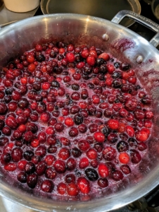 Meanwhile, on the stove cooking are two large pots of beautiful cranberries.
