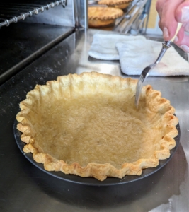 I also prick the bottom of the crust a few times with the tines of a fork. This is called docking, the culinary term for poking holes in a pie crust. The holes allow steam to escape, so the crust should stay flat against the baking dish when it isn’t held down by pie weights or a filling. Otherwise the crust can puff up, ruin its appearance, and leave less space for whatever filling is planned.