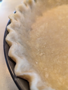 Next, using my fingers I decoratively crimp the crust. Crimping is not only decorative, but it makes it less likely the sides of the pie will fall or shrink during baking.