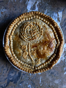 And Serena "made a traditional apple pie and created an heirloom chrysanthemum with the crust to tie-in with the heirloom chrysanthemums etched on the vintage serving dishes."