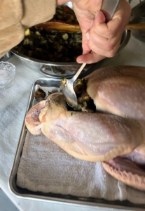 Once the turkey is patted dry and seasoned, I spooned several cups of apple and pear stuffing inside the bird's cavity. The capacity of the cavity will vary with every bird. Any remaining stuffing can be baked separately.