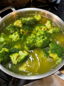 First, I cut up heads of broccoli and boil them until tender.