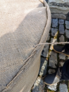 There is a lot of tucking involved to make it neat, and a lot of stitching and knotting, but my crew has been covering these containers with burlap every year for quite some time – they are all excellent burlap sewers.