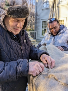 Fernando works on top and Pete sews the sides. There is a lot of tucking involved, and a lot of stitching and knotting, but my crew has been covering these containers with burlap every year for quite some time – they are all excellent burlap sewers.