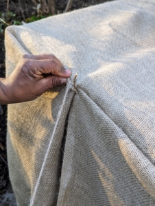 Pete makes small stitches and knots to keep the burlap in place. I remind the crew to wrap them like they would gifts - make the folds tight and even as possible.