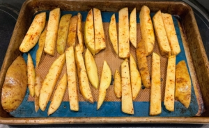 The fries are placed on a rimmed baking sheet and roasted on the upper rack of the oven until golden-crisp, about 30 to 35 minutes long.