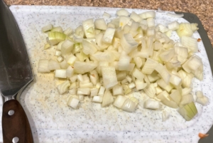 Next, the yellow onions are finely chopped. And, do you know why onions make one cry? Onions contain amino acids known as cysteine sulfoxides. When an onion is cut, chopped, or torn, enzymes in the onion break down the cysteine sulfoxides and turn them into propanethial S-oxide, which then decomposes into sulfuric acid resulting in the irritation, stinging, and tearing that is associated with cutting onions. To cut onions without crying, try chilling them in the refrigerator for about 30 minutes first. The cold temperature will slow down the enzymes and ease the irritating effects.