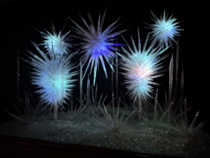 This is called Winter Brilliance, 2015. Winter Brilliance was originally created for the Barney's New York flagship store in Manhattan for its famous annual holiday window display. Installed at Chihuly Garden and Glass in 2021, Winter Brilliance features chandeliers, towers, reeds, and these icicle clusters.