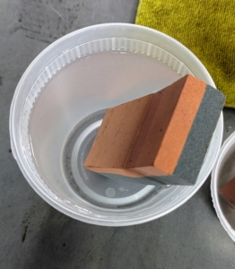 This larger block is also soaking in tepid water. This piece is helpful for longer blades.