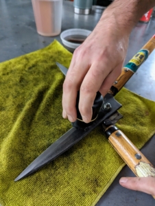 And then oils the entire piece. Here, he also oils the joint where the two sides meet. After oiling, it is a good idea to open and close the pruners to hear how the parts move together – they should work smoothly, quietly, and evenly.