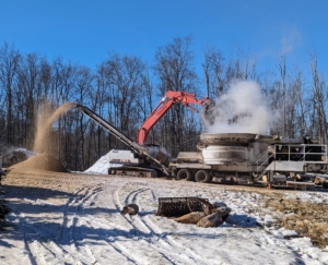 Here's the tub grinder at work on the first day. The excavator is used to pick up the material using its large “jaws grab” bucket attachment to drop debris into the tub grinder.