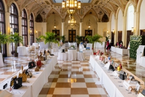 The event originally began in 1999 by a group of supporters who donated their gently used handbags for auction. 25-years later, there are hundreds donated - some old and others brand new from retail partners. Here they are displayed in the Ballroom of The Breakers Palm Beach Resort founded in 1896 by business magnate Henry M. Flagler. (Photo by Carrie Bradburn/CAPEHART)
